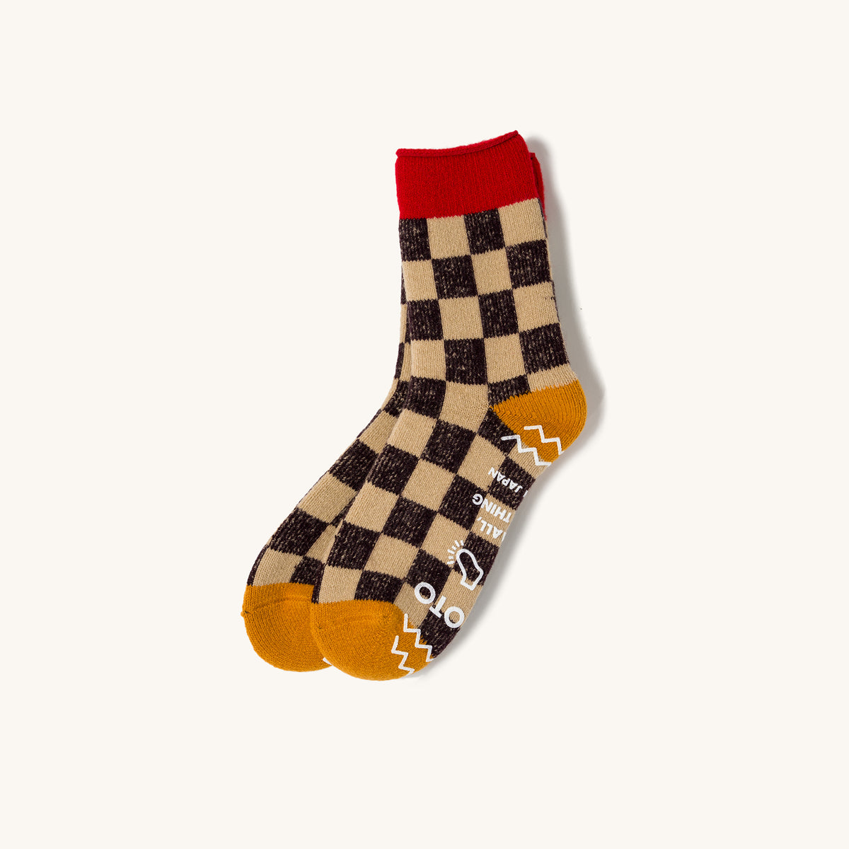 Checkered pile sock by Pile Room with red cuff, yellow toe, and white graphic text on brown and beige squares.