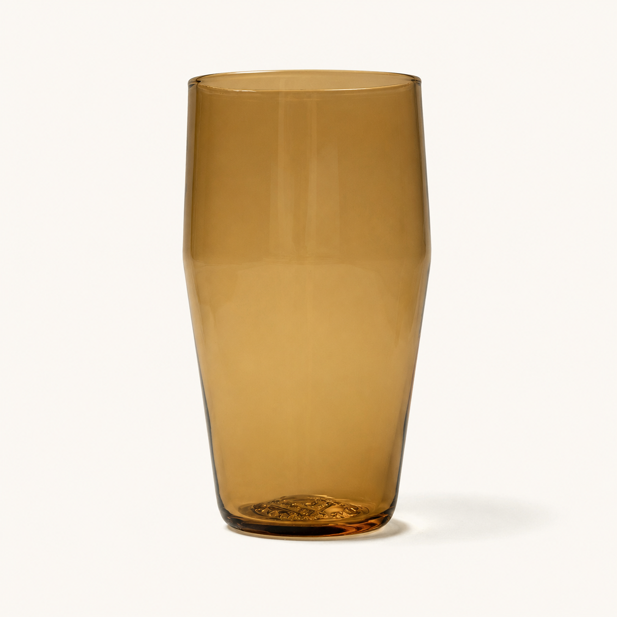 Amber tinted standard pint glass with textured base, front view, clear glassware design