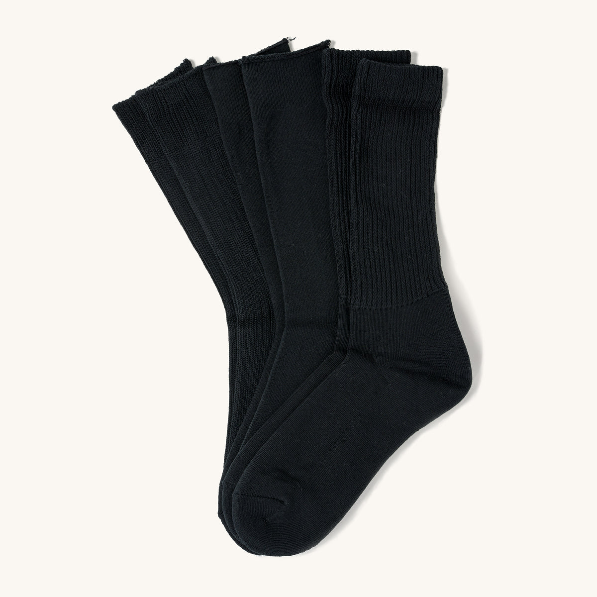 Three pairs of black crew socks with ribbed cuffs, layered side by side on a light background.