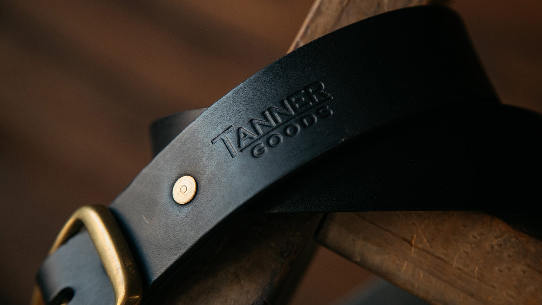Close up shot of Tanner Goods monogram on a black leather belt.