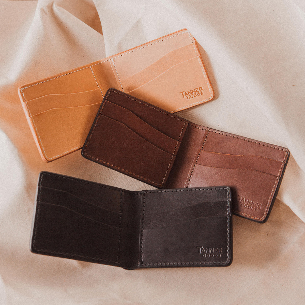 Three bifold wallets laying open