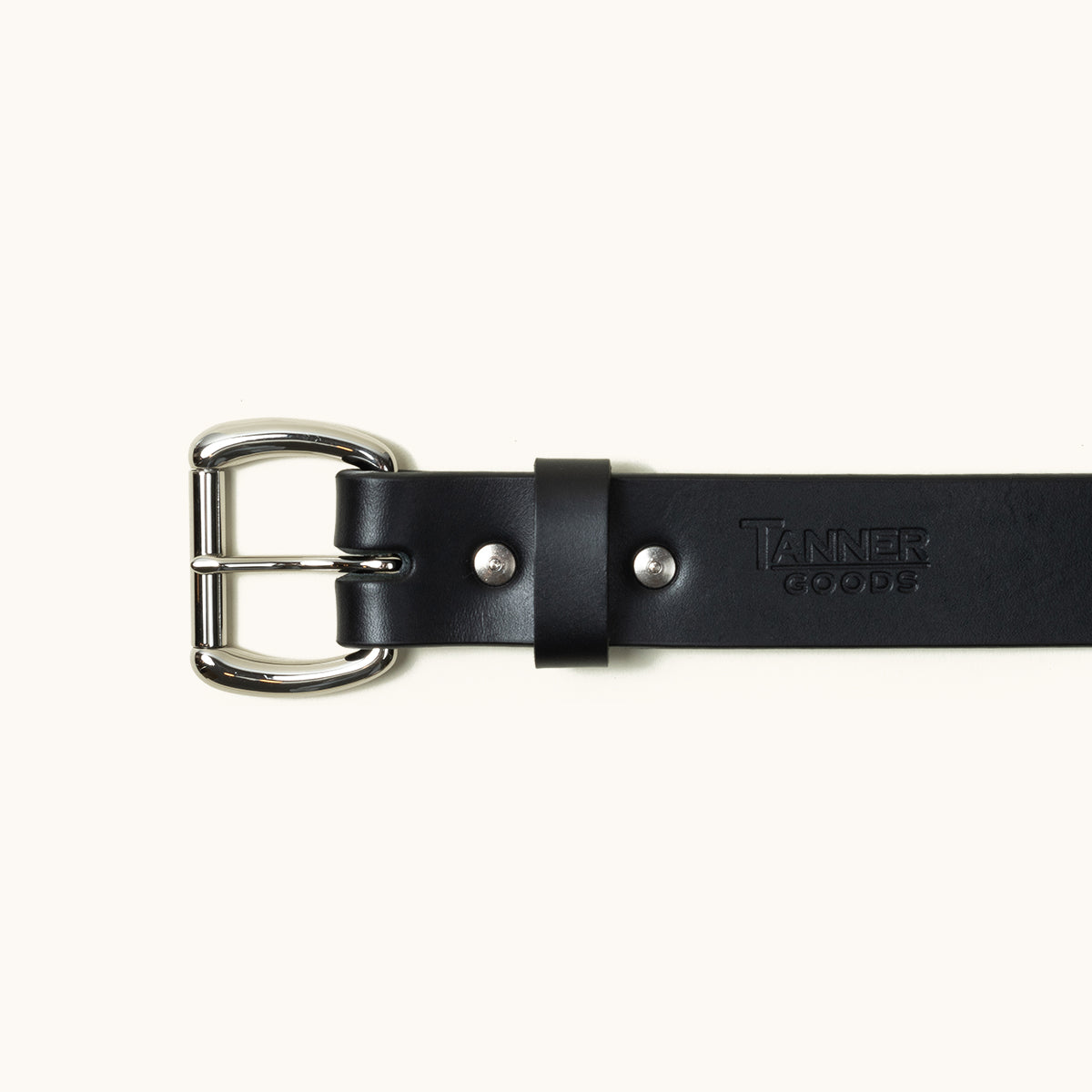 The top half of a black Standard belt showing a stainless roller ball buckle and Tanner Goods logo stamped into the belt.