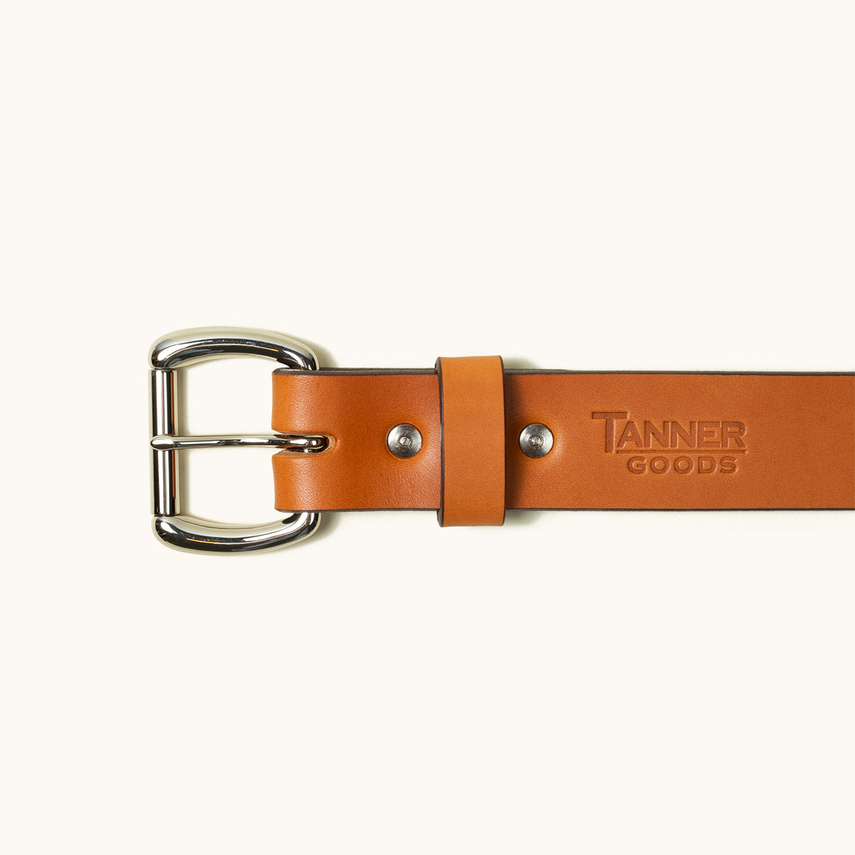 The top half of a Saddle Tan Standard belt showing a stainless roller ball buckle and Tanner Goods logo stamped into the belt.