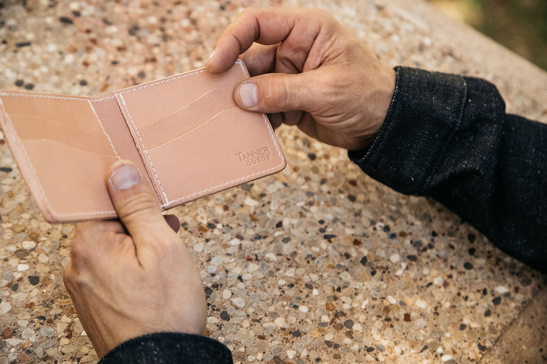 Hands opening a natural Utility Bifold.