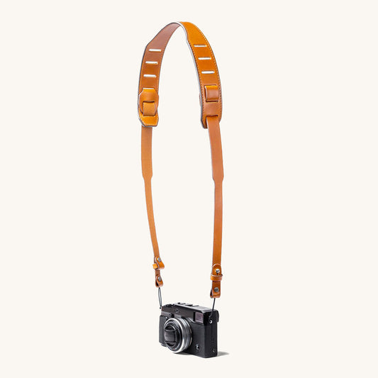 A silver and black SLR camera with a black leather strap.