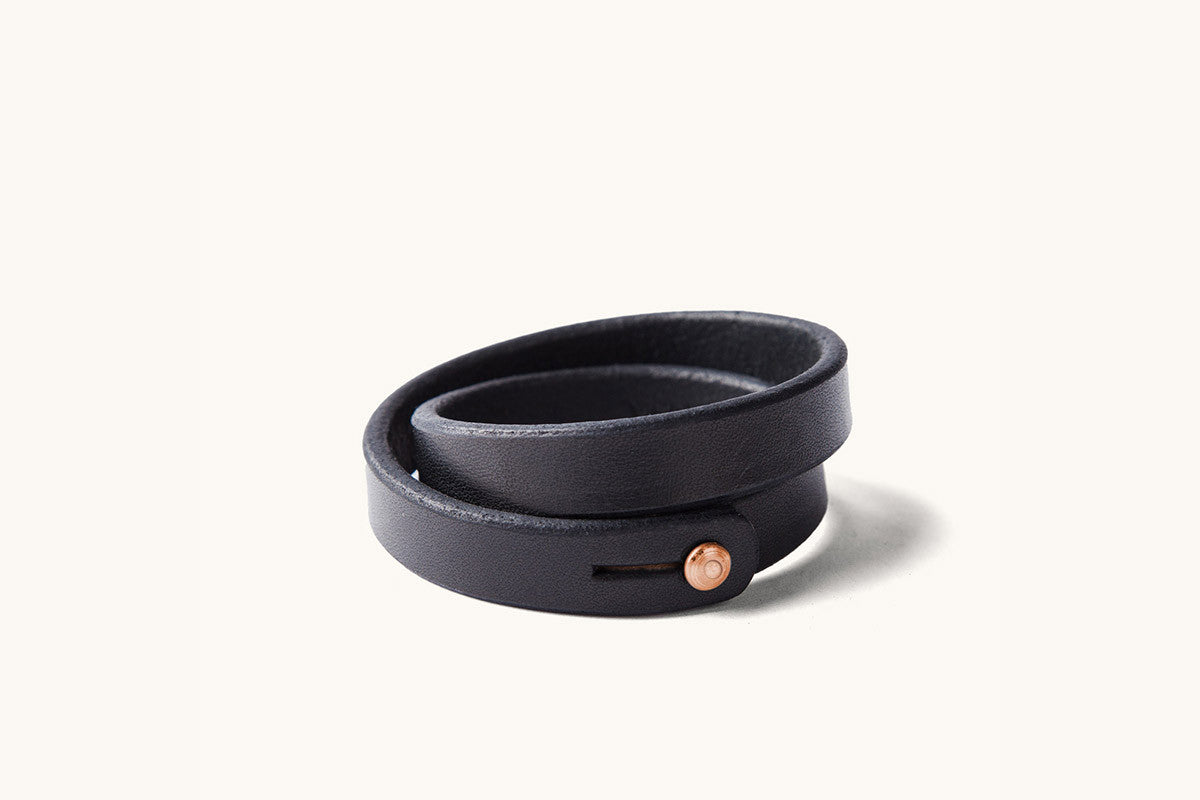 A double wrap black leather wristband with copper closure.