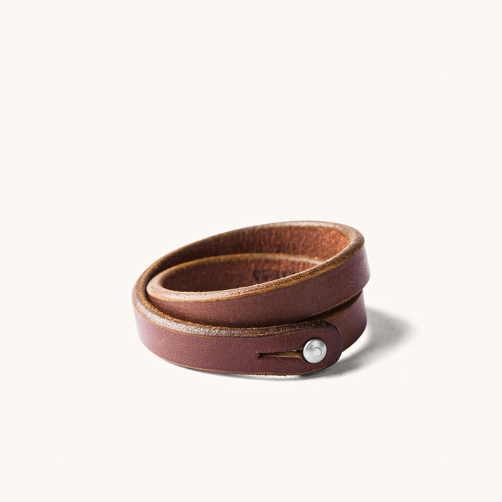 A double wrap brown leather wristband with metal closure.