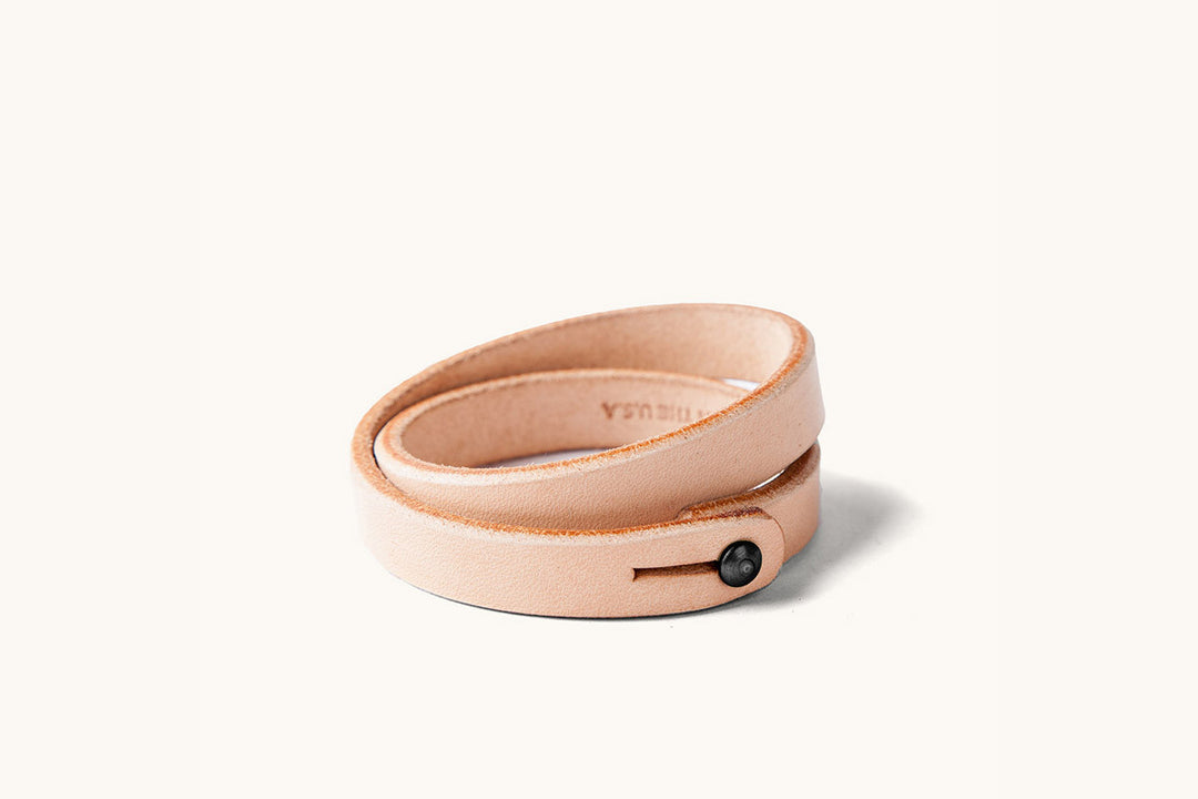 A double wrap natural leather wristband with black closure.