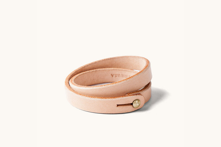 A double wrap natural leather wristband with brass closure.