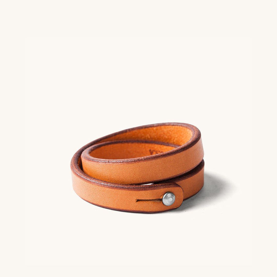 A double wrap tan leather wristband with metal closure.