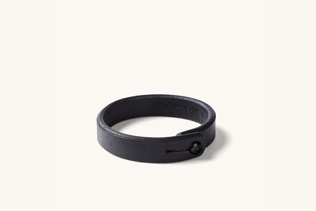 A black leather wristband with black rivet closure.