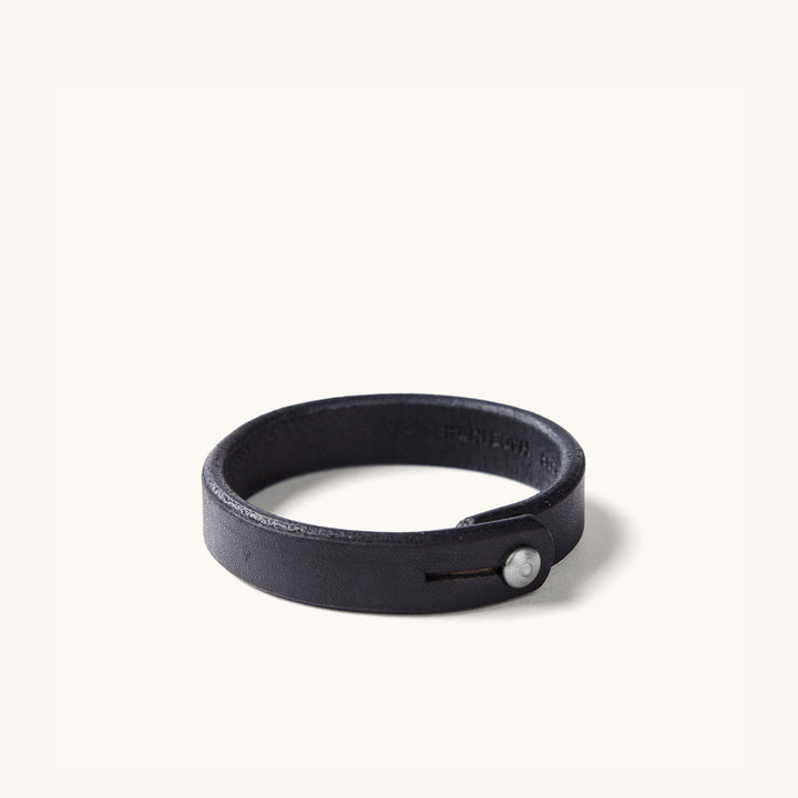 A black leather wristband with metal rivet closure.