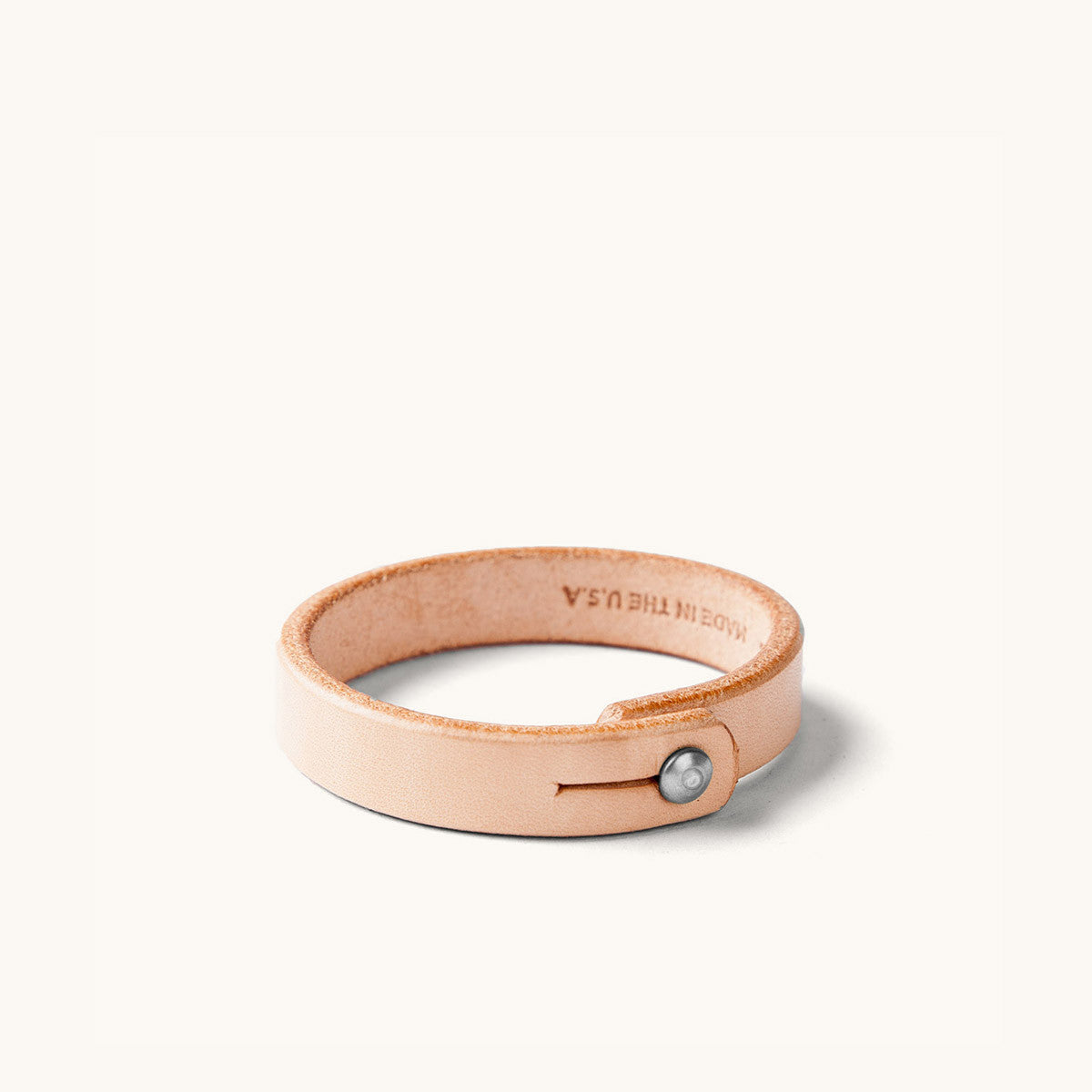 Natural leather wristband with metal rivet closure.