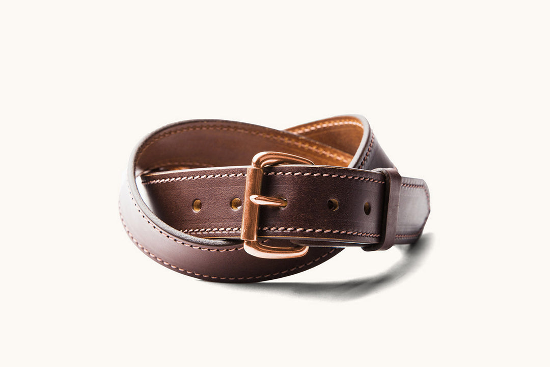 a brown leather belt with copper hardware and stitching