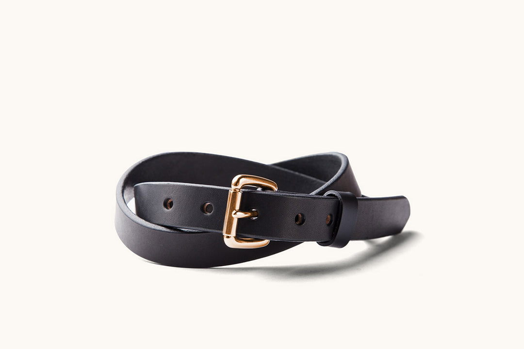 a skinny black leather belt with copper roller buckle