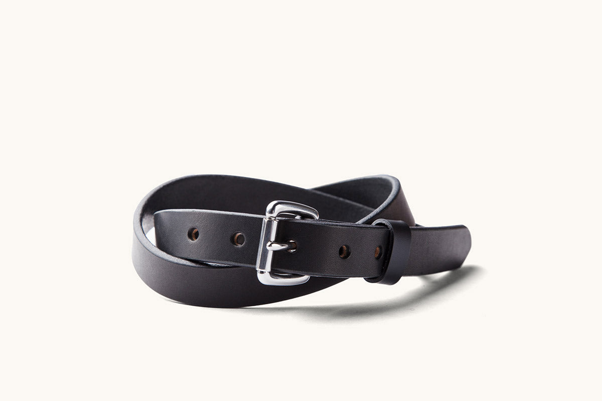 a skinny black leather belt with silver roller buckle