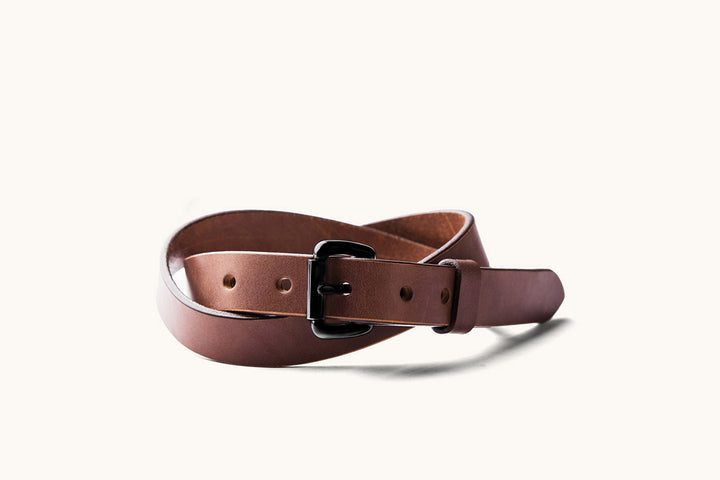 a skinny brown leather belt with black roller ball buckle