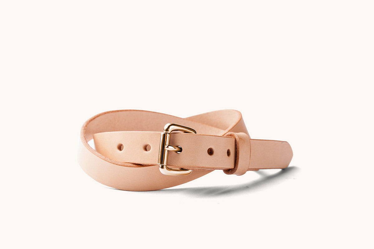 a sand colored leather belt with a copper roller ball buckle