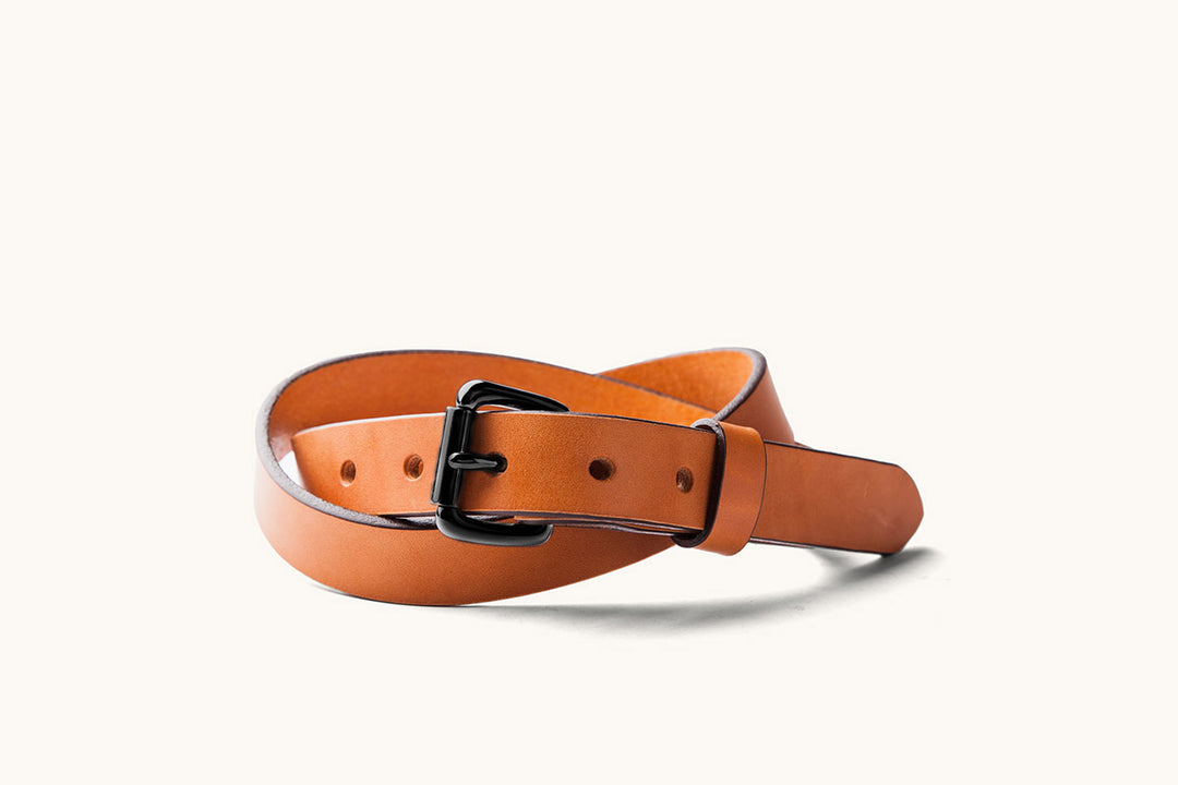 a saddle tan leather belt with black roller buckle