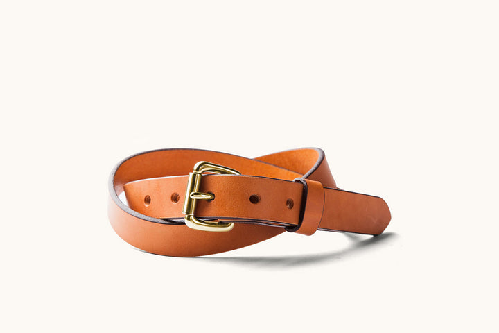 a saddle tan leather belt with brass roller buckle