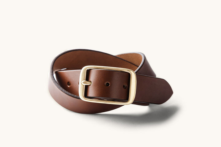 a coiled brown leather belt with a cast brass buckle
